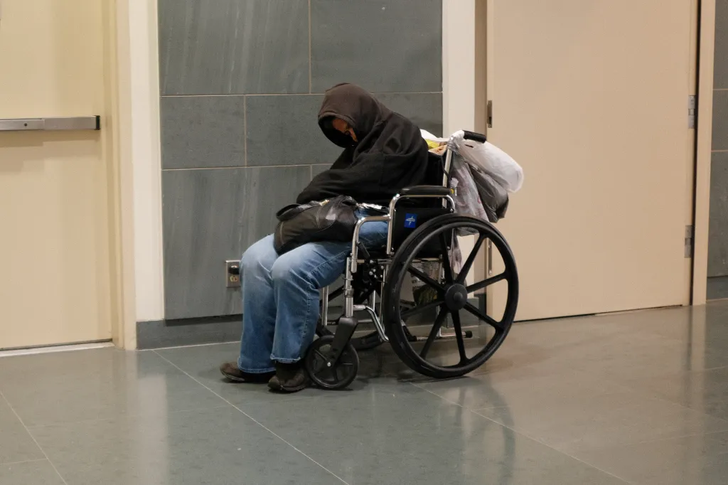 An unhoused individual in a wheelchair at the Los Angeles Central Library.