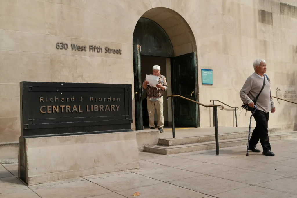 Two unhoused individuals outside the Los Angeles Central Library.
