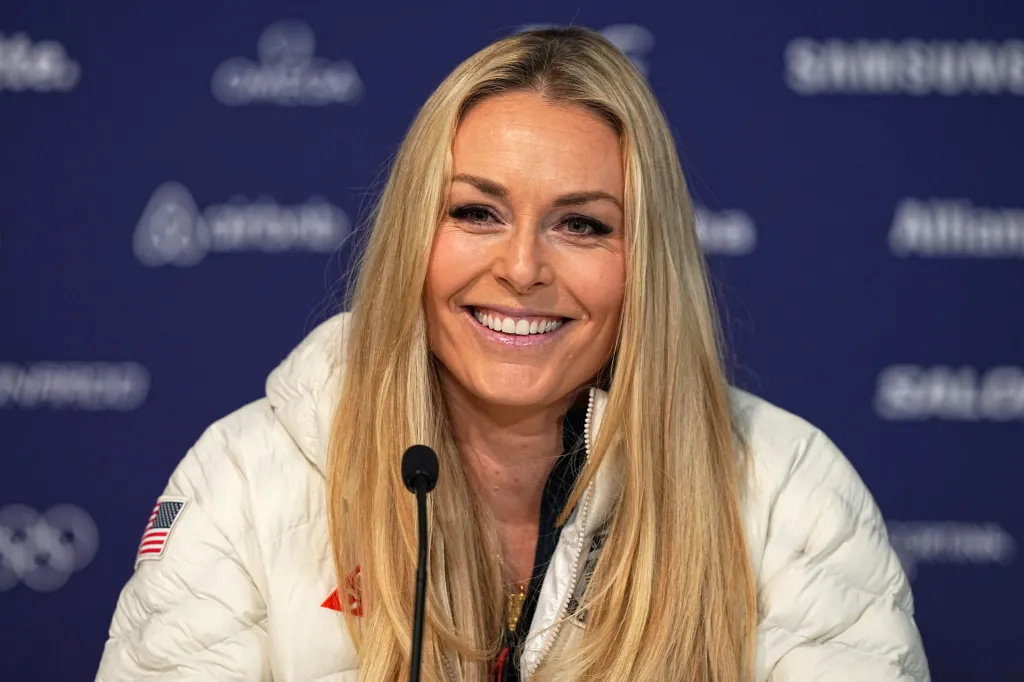 Lindsey Vonn smiling while speaking at a press conference.