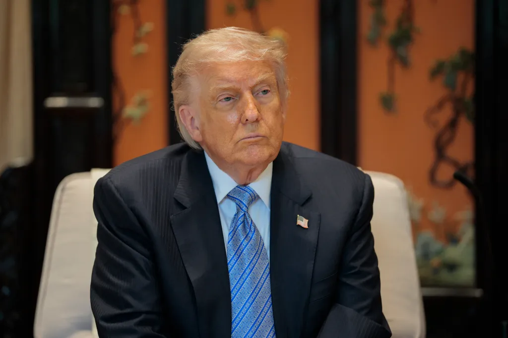 Donald Trump sits at a meeting.