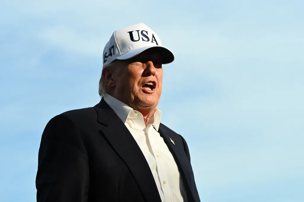 US President Donald Trump speaks to reporters while wearing a white 