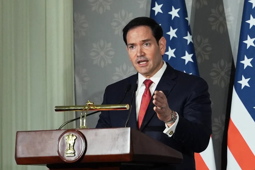 US Secretary of State Marco Rubio speaks at a podium with US flags in the background.
