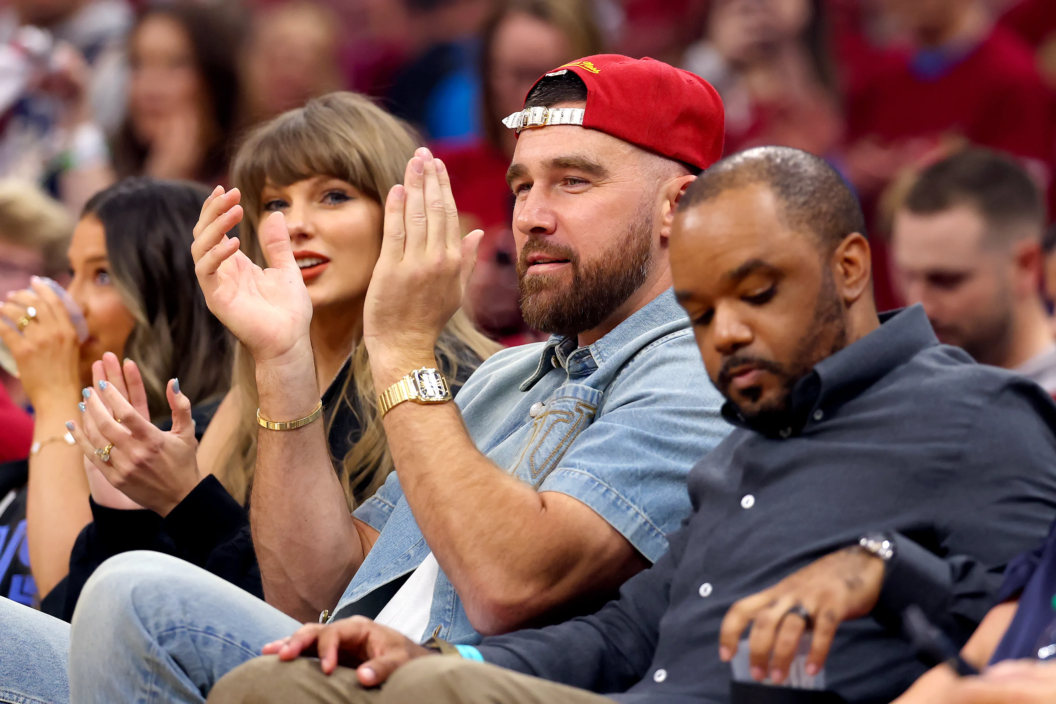 Taylor Swift and Travis Kelce clapping at an NBA game.