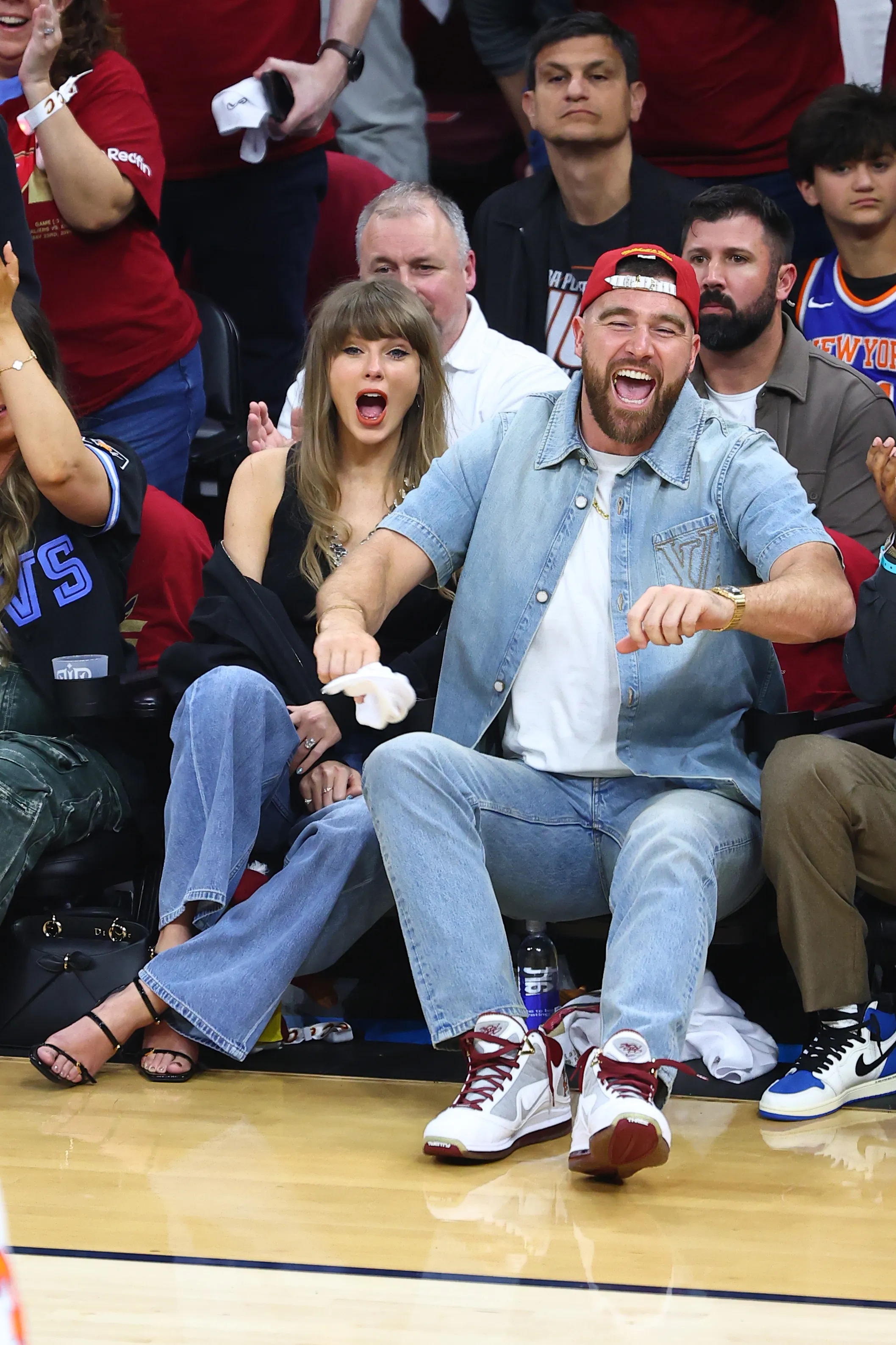 Taylor Swift and Travis Kelce cheering during a basketball game.