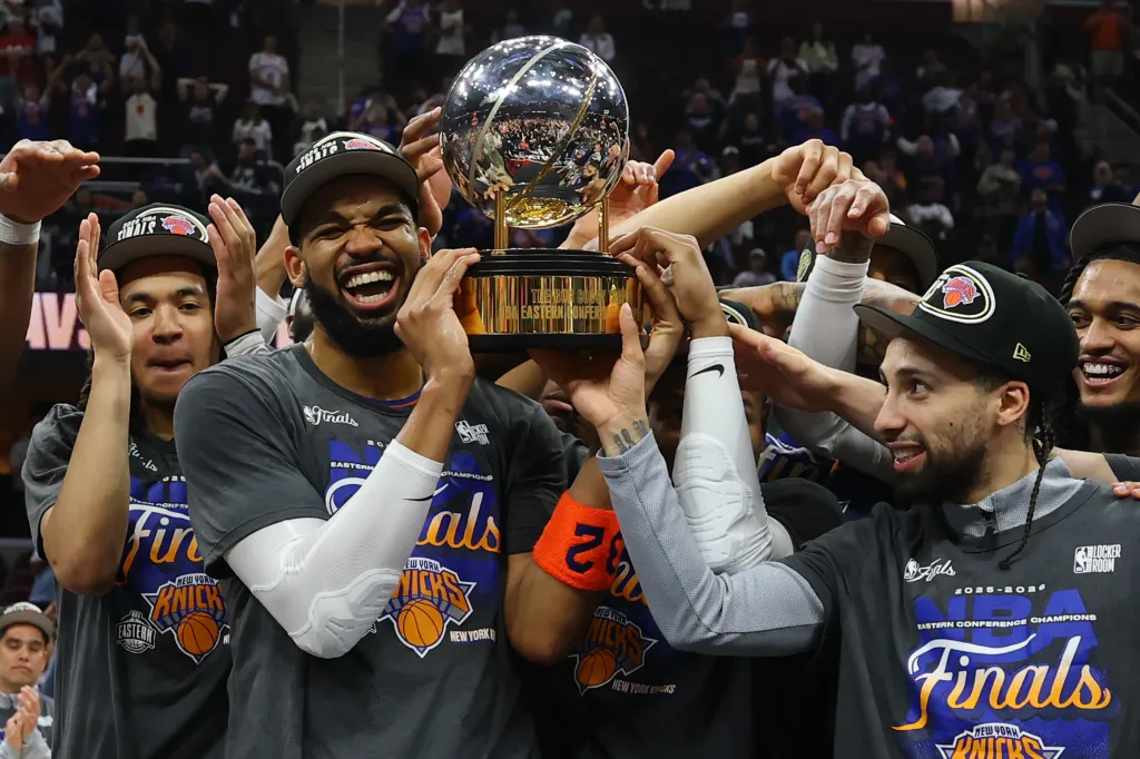 New York Knicks players celebrate with the Bob Cousy Trophy after winning the NBA Eastern Conference Finals.