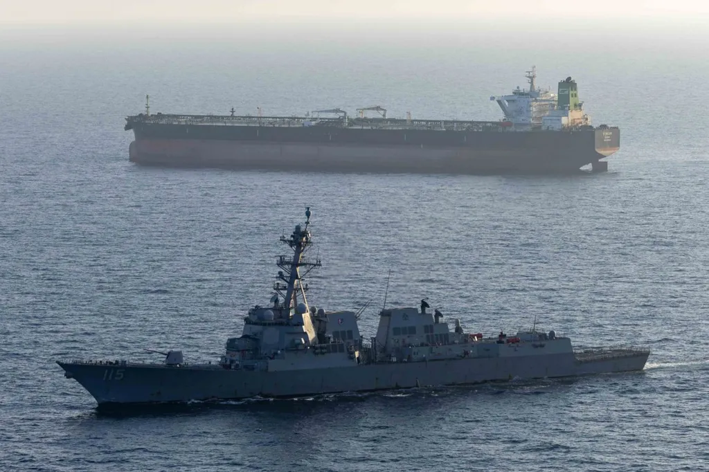 The US Navy guided-missile destroyer USS Rafael Peralta sailing in the foreground with the M/T Stream tanker in the background.