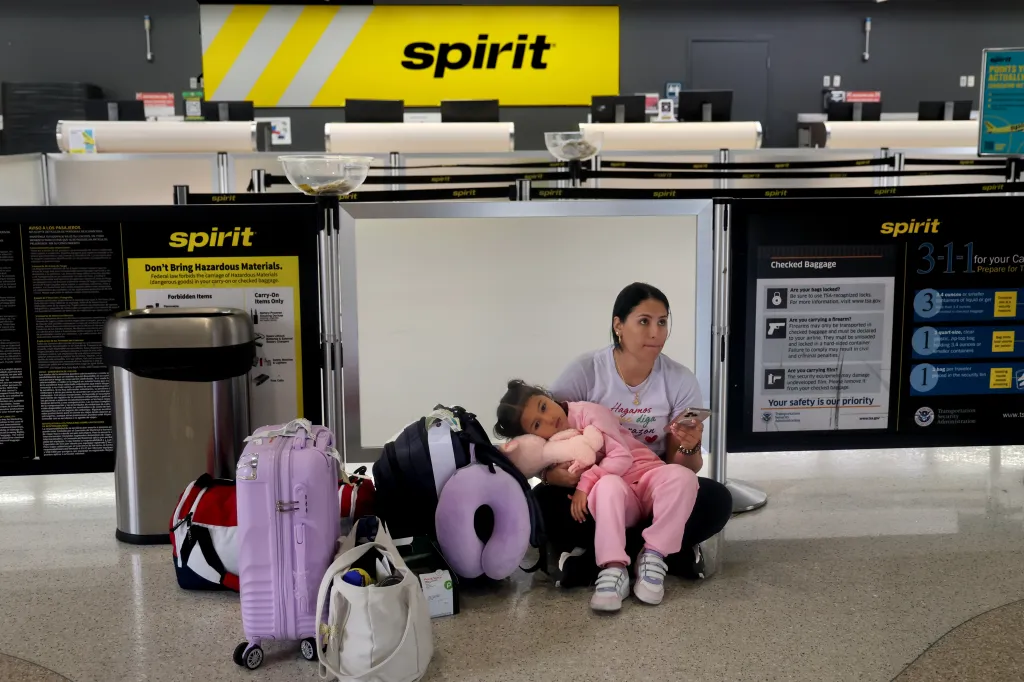 A woman holds her daughter at a Spirit Airlines check in in Fort Lauderdale, Florida after the airline shut down operations on May 2, 2026.