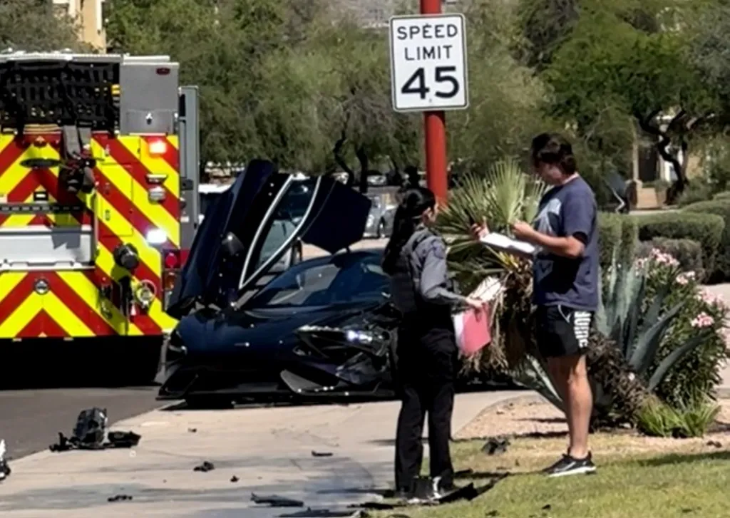 Trevor Bauer talks with police after crashing his $600,000 McLaren in Arizona Wednesday.