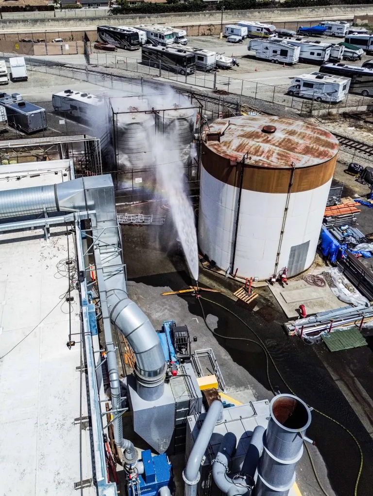 Water spraying on industrial tanks during a hazardous chemical leak in Garden Grove.