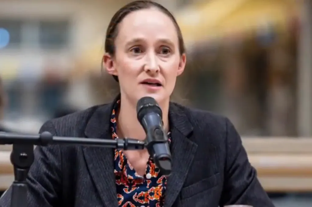 Woman speaking at a microphone.
