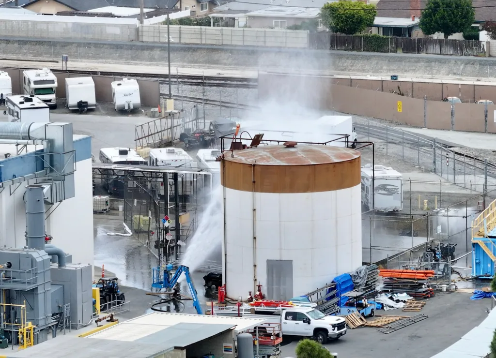 Water being sprayed onto an overheating chemical tank at an aerospace plant.