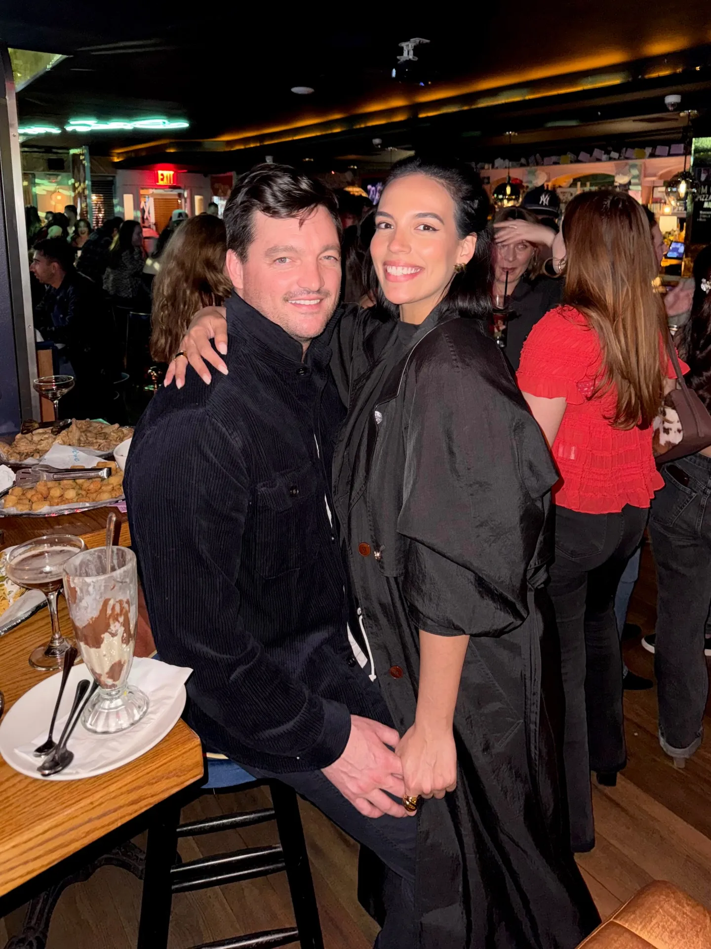 Danielle Olivera and Eoin Heavey posing together at a bar.