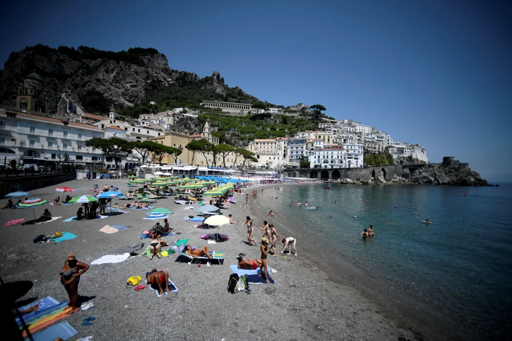 Tourists and residents sunbathing and swimming at a beach in Amalfi on the Amalfi coast in southern Italy.