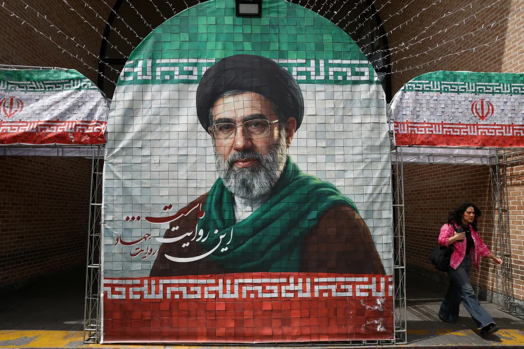 A woman walks past a banner depicting Iran's new Supreme Leader Mojtaba Khamenei in Tehran.