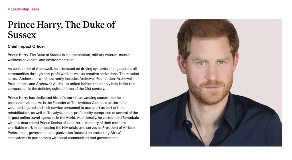 Photo of Prince Harry, the Duke of Sussex,in a black shirt, looking directly at the camera.