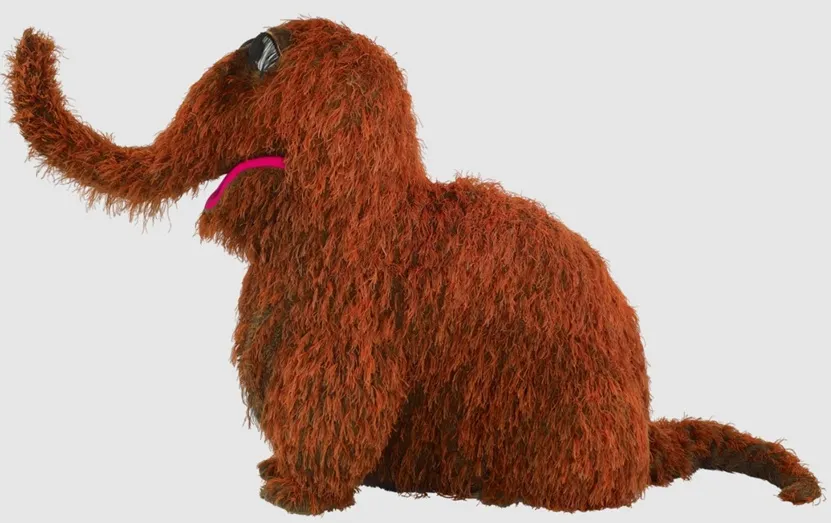 A full-body image of Snuffleupagus, a large brown Muppet with a long trunk, small eyes, and a pink mouth, facing left.