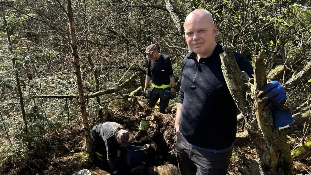 Men working to uncover an ancient gold sword relic.