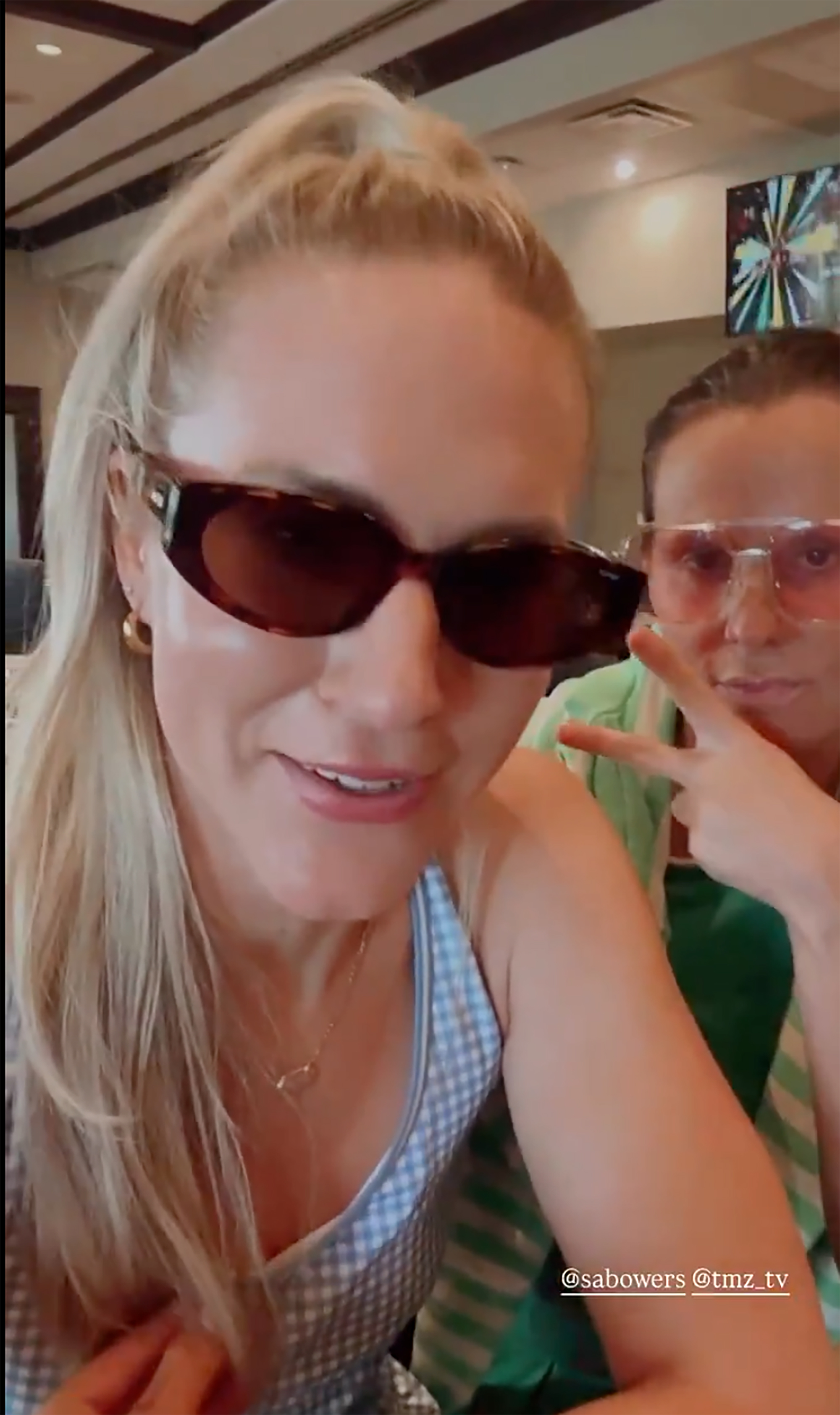 Caitlin Rance wearing sunglasses and drinking a beverage, with Sarah Jane Ramos's bridesmaid next to her.
