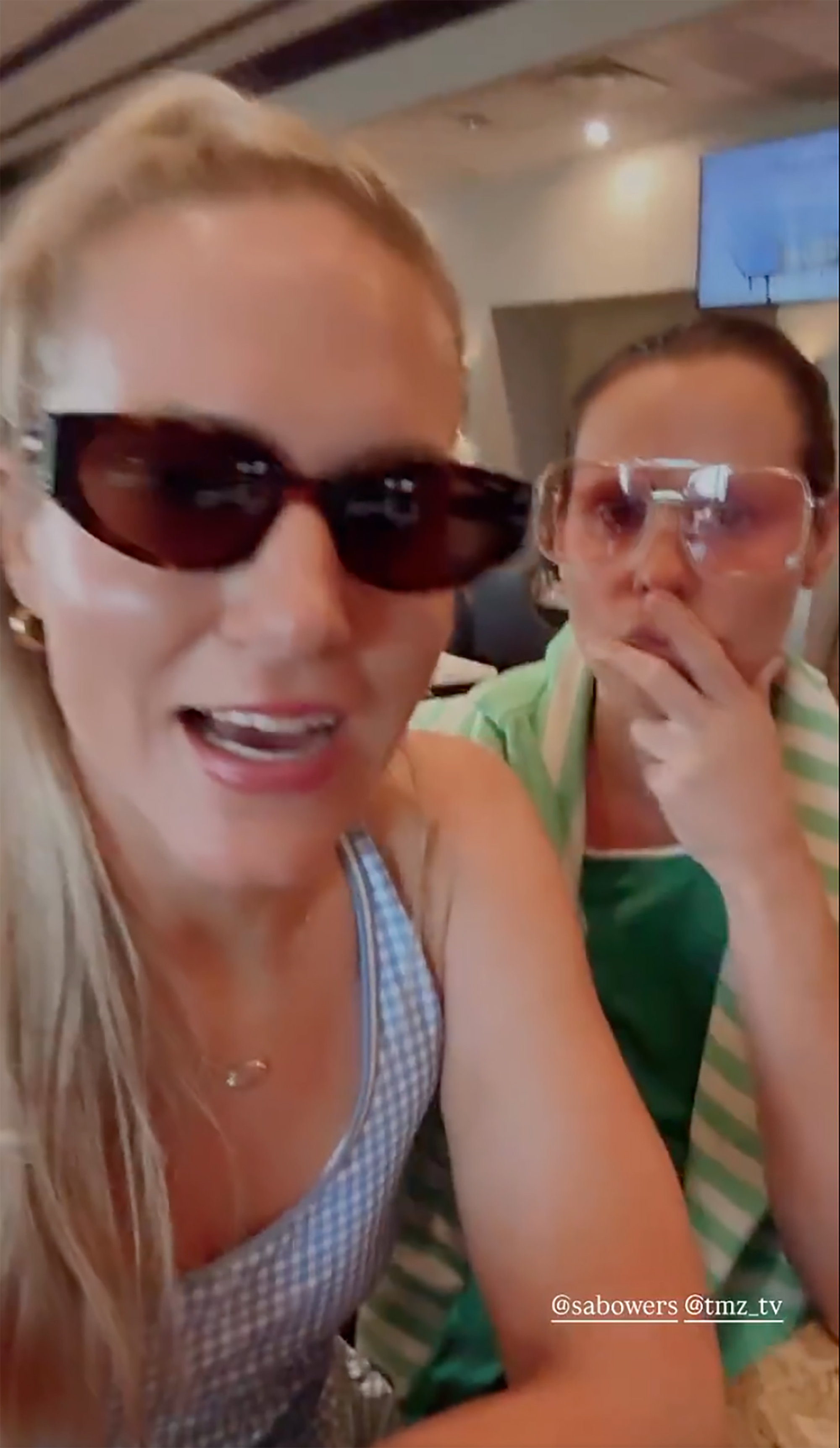 Two women wearing sunglasses, one in a blue and white checkered dress and the other in a green and white striped top.