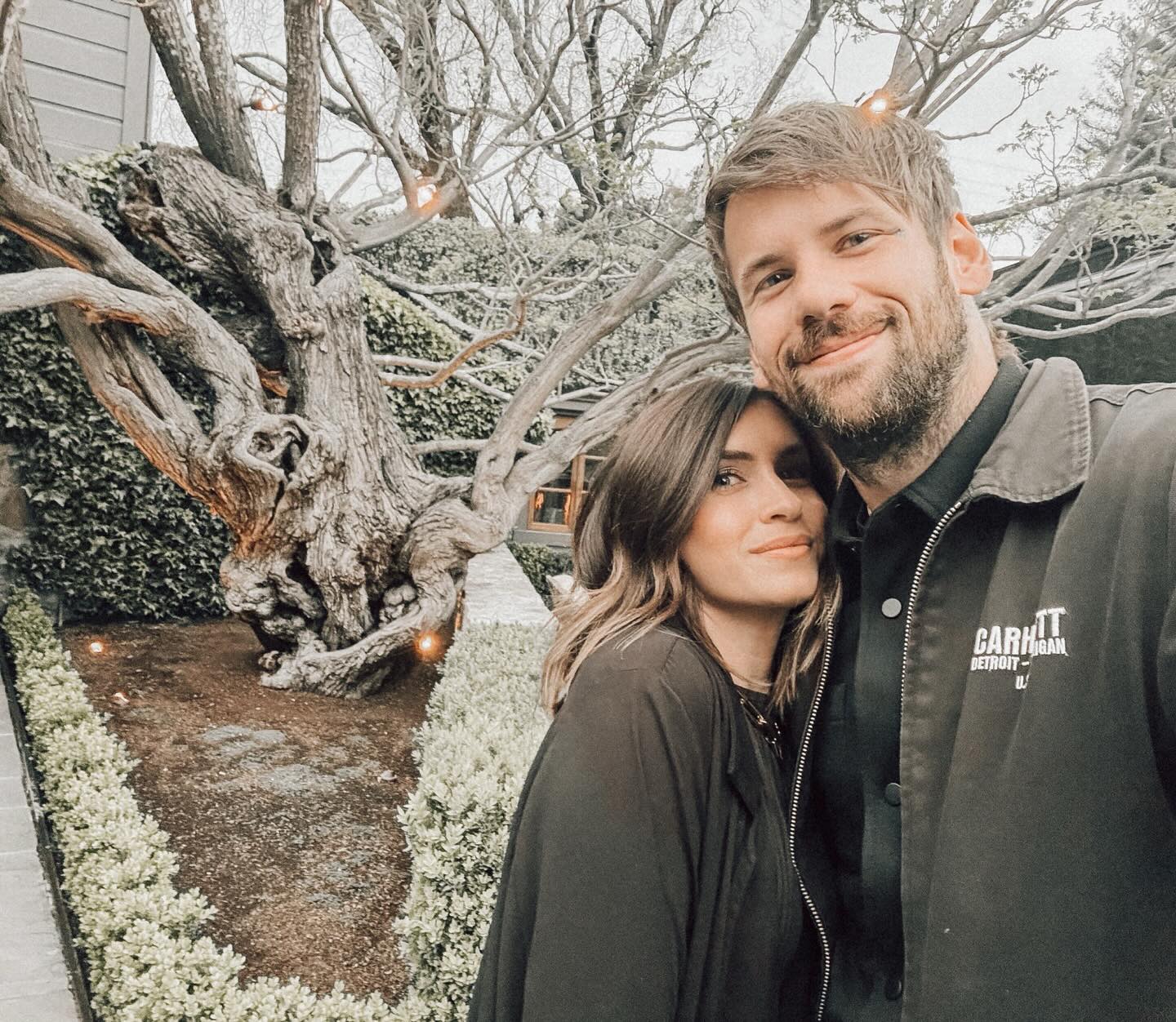 Caleb Shomo and his wife in a selfie outdoors.