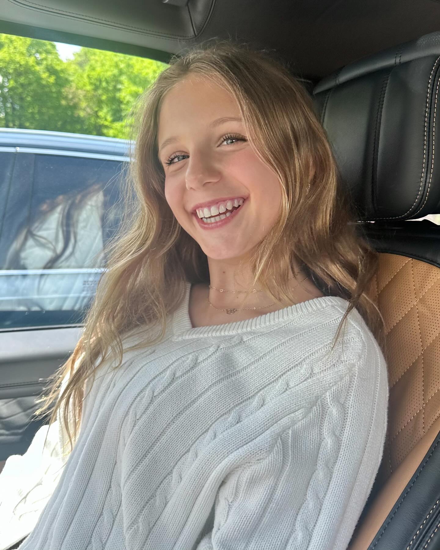 Bethenny Frankel's daughter Bryn smiling in a car.