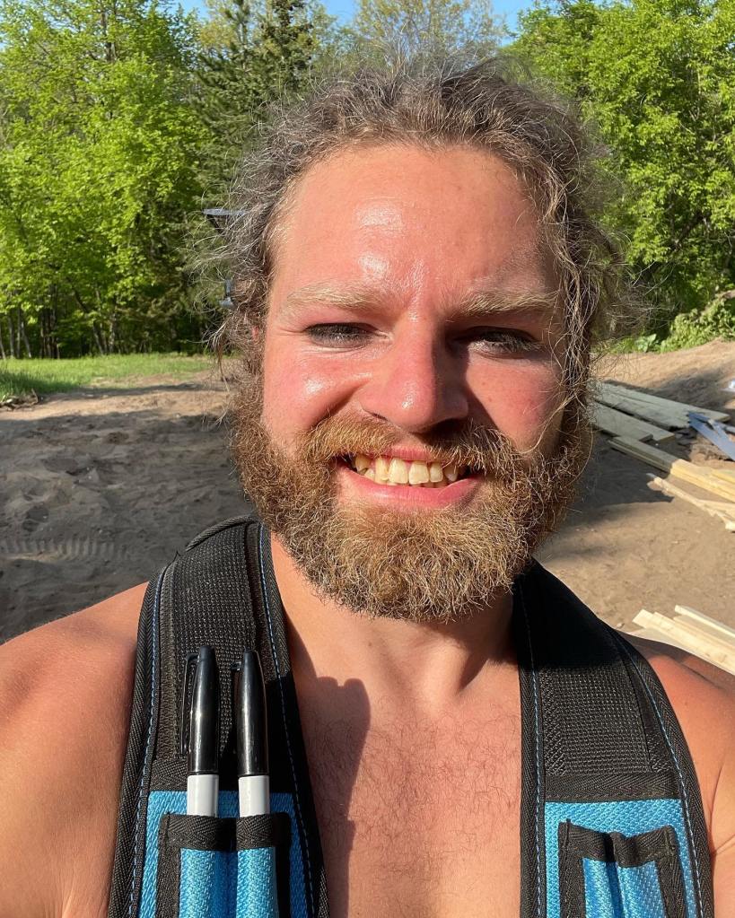 Matt Brown's brother Gabe smiling with two markers in his work straps.