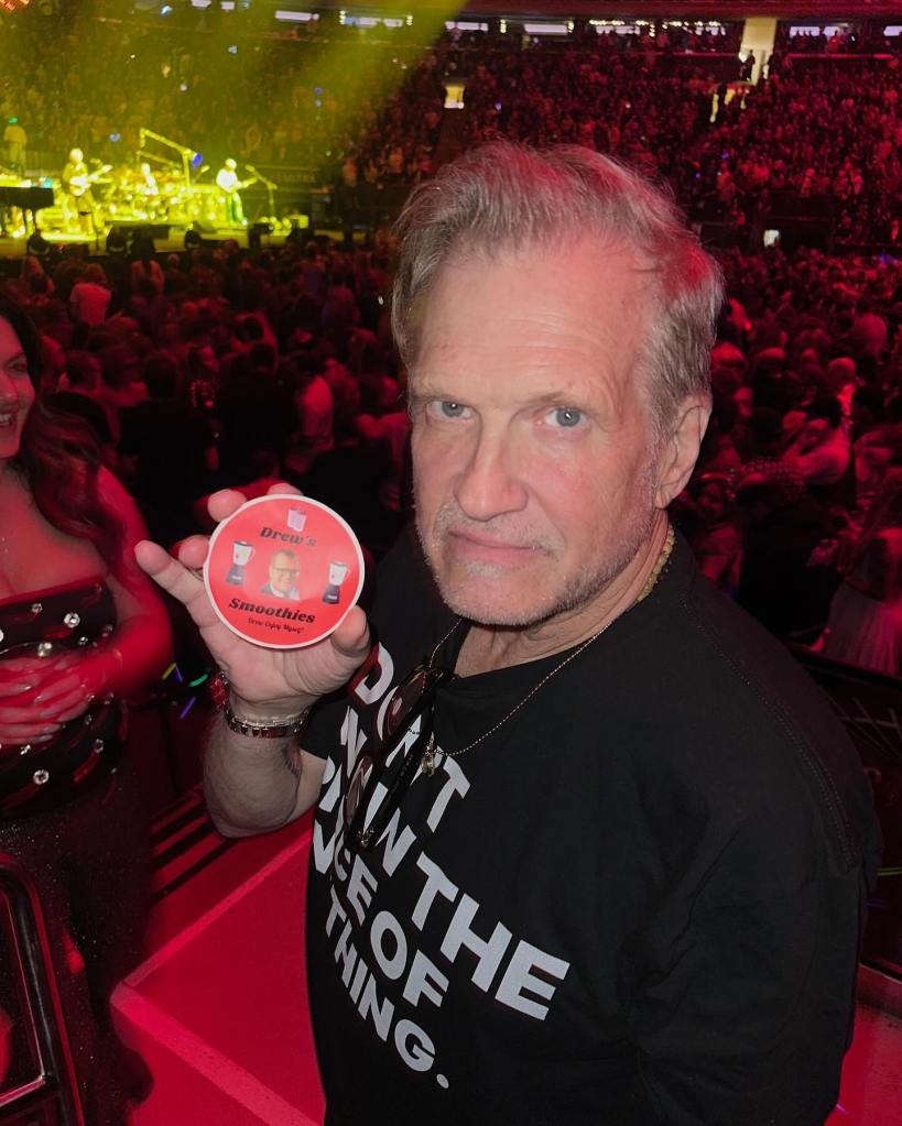 Drew Carey holds up a