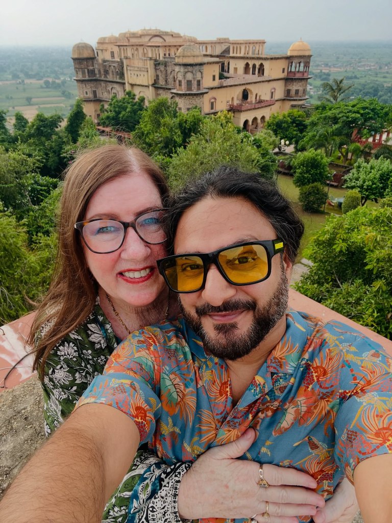 Jenny Slatten and Sumit Singh smiling for a selfie with a historic building in the background.