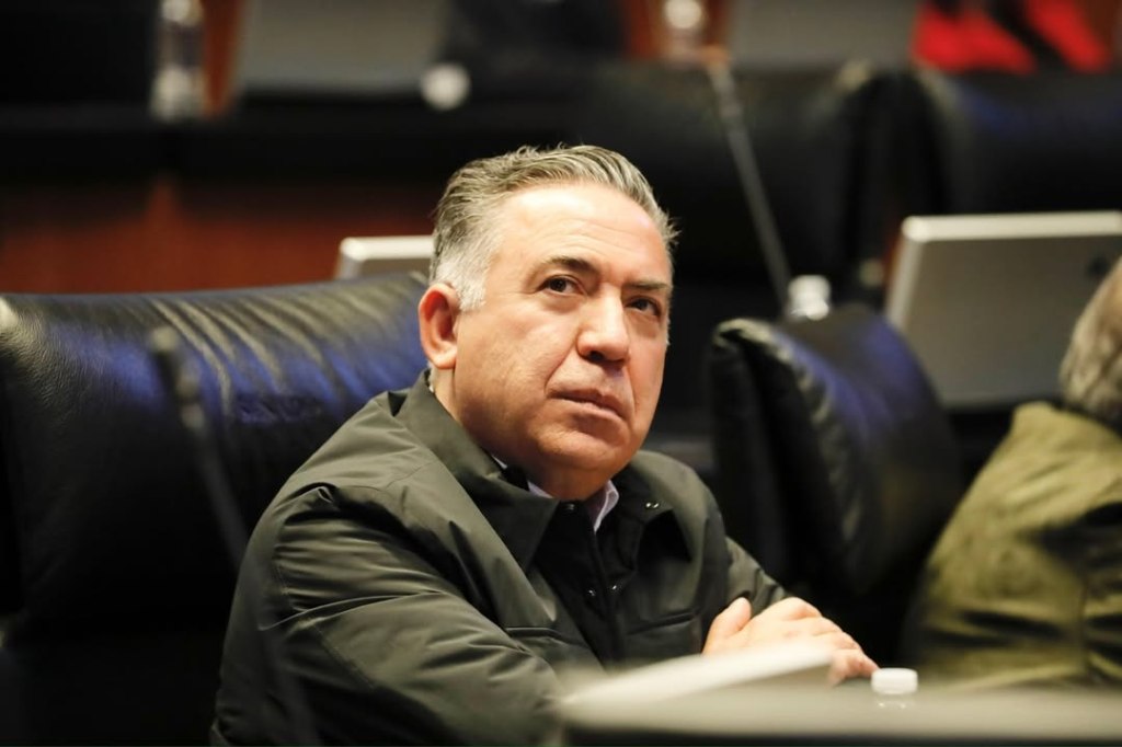 Enrique Inzunza Cázarez sitting in a dark chair, looking slightly upwards with a neutral expression.