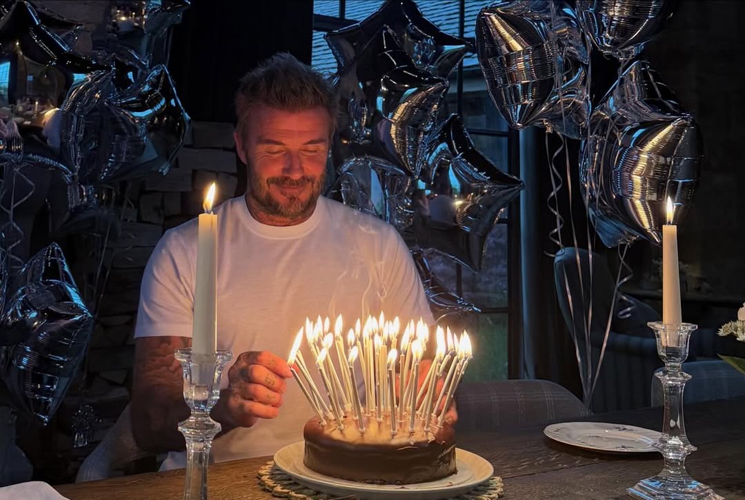 David Beckham celebrating his birthday, lighting candles on a chocolate cake.