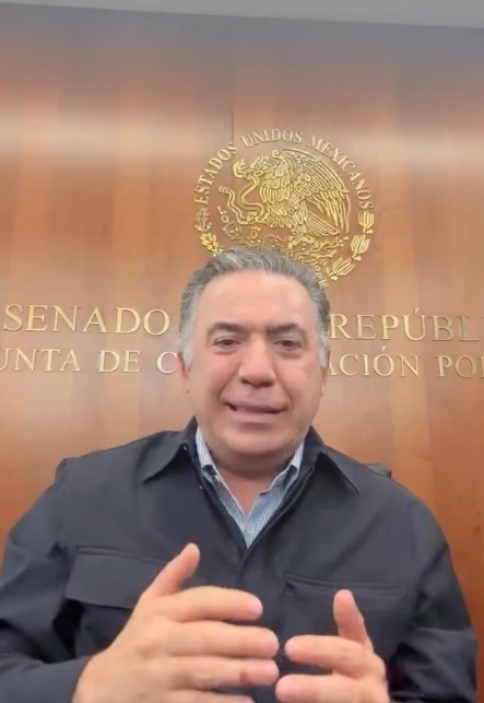 Enrique Inzunza Cázarez speaking, with the Mexican coat of arms and text 