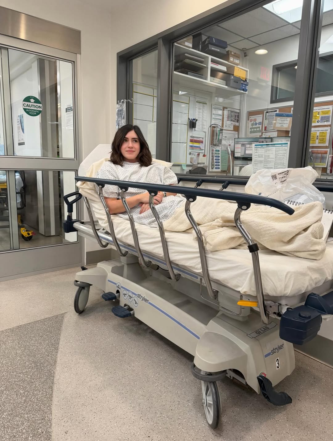 Fleur Shomo sitting in a hospital bed in a gown.