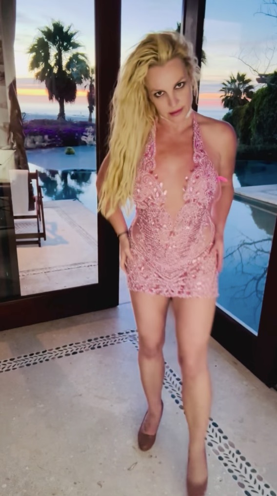 Britney Spears dancing in a pink and lace mini dress.