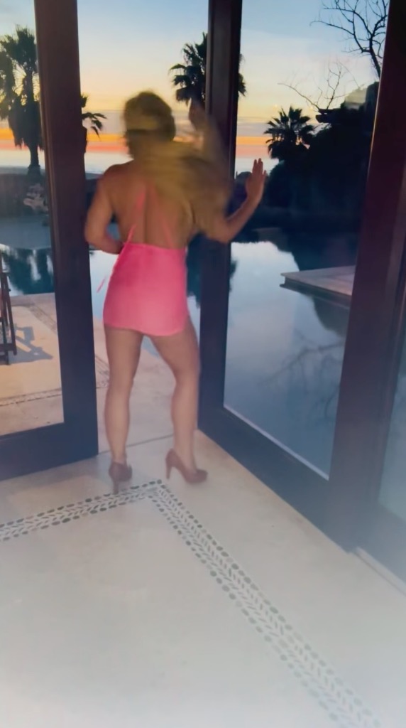 Britney Spears dancing in a pink dress and high heels.