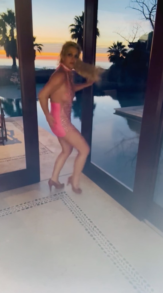 Britney Spears dancing in a pink dress and high heels.