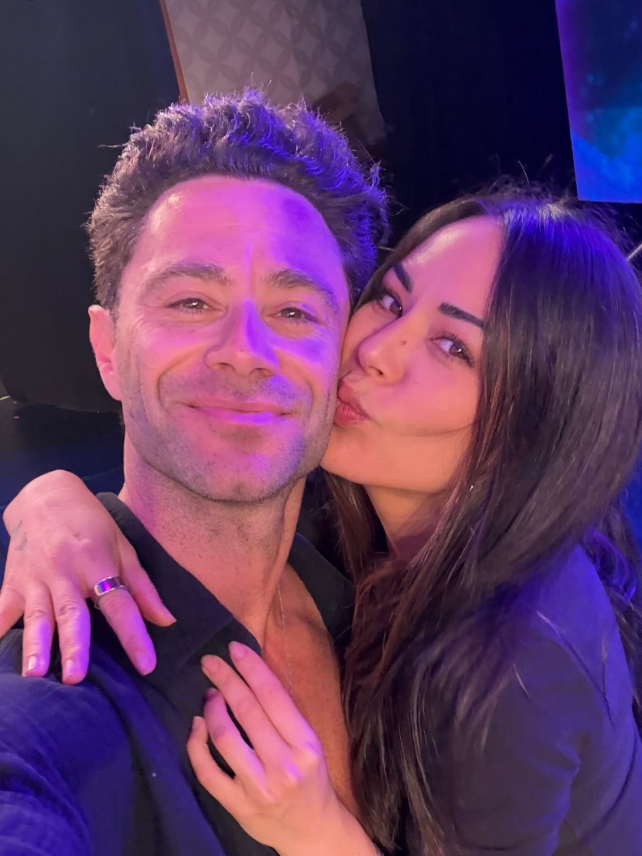Janel Parrish kisses Sasha Farber on the cheek.