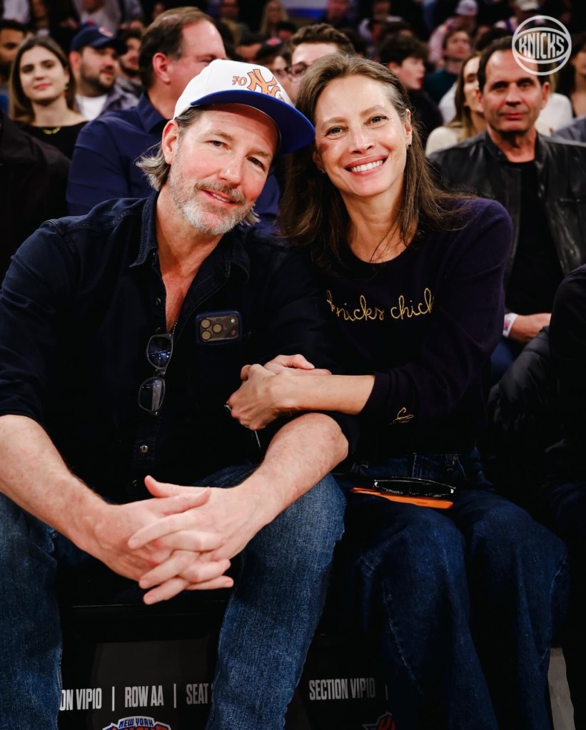 Christy Turlington and Ed Burns smiling together at a Knicks game.