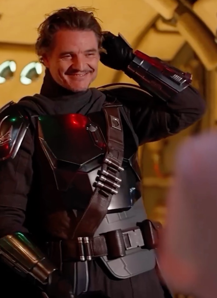Pedro Pascal dressed as the Mandalorian, smiling.