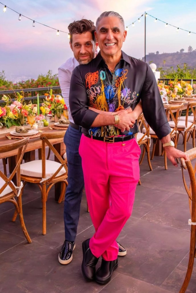 Reza Farajhan and his husband, Adam, pose together outdoors.