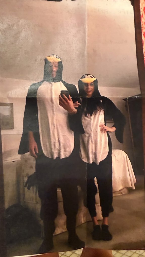 Meghan Markle and Prince Harry wearing penguin onesies.