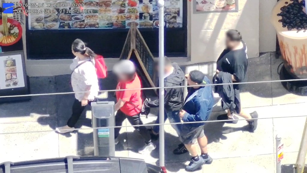 Security camera footage shows three people targeting a person in a red shirt.