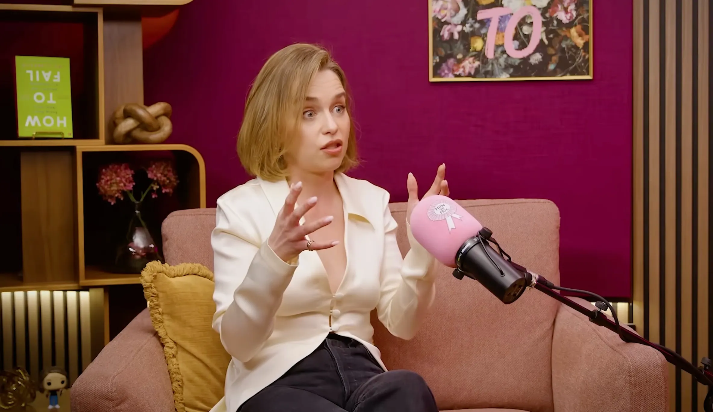 Emilia Clarke talking to a pink microphone.