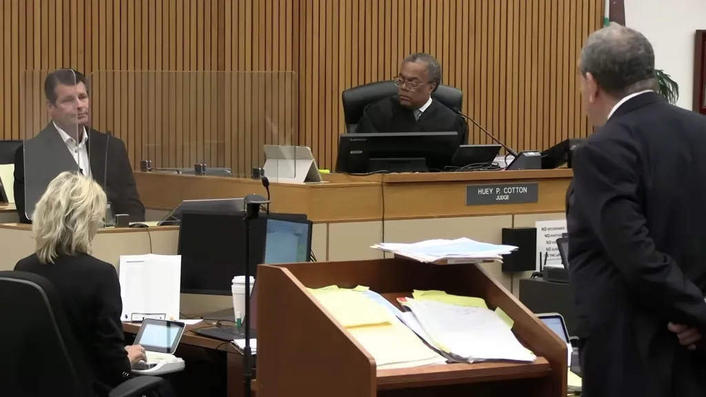 Scott Erickson in court, seated behind a plexiglass barrier, facing the judge.