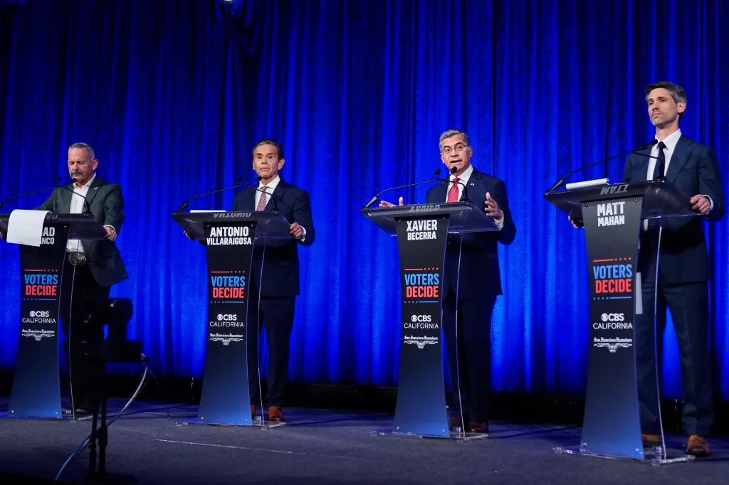 Four men, Chad Bianco, Antonio Villaraigosa, Xavier Becerra, and Matt Mahan, stand at separate podiums during a California gubernatorial debate.