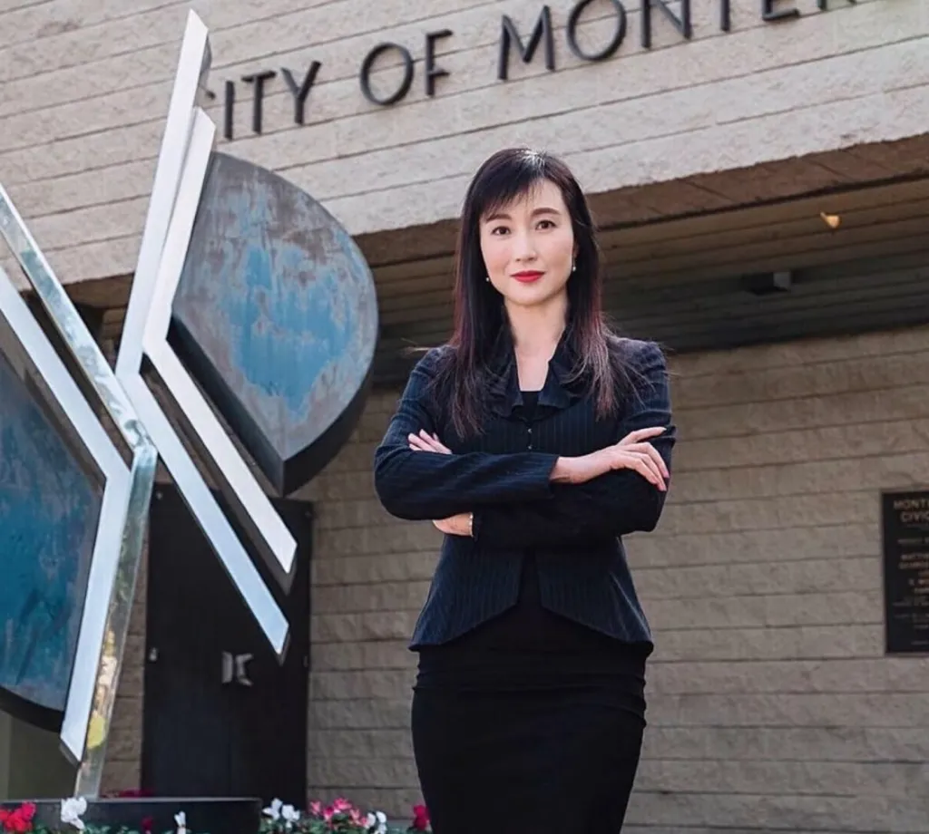 Yvonne Yiu, a financial business leader and former mayor, stands with her arms crossed in front of a building with