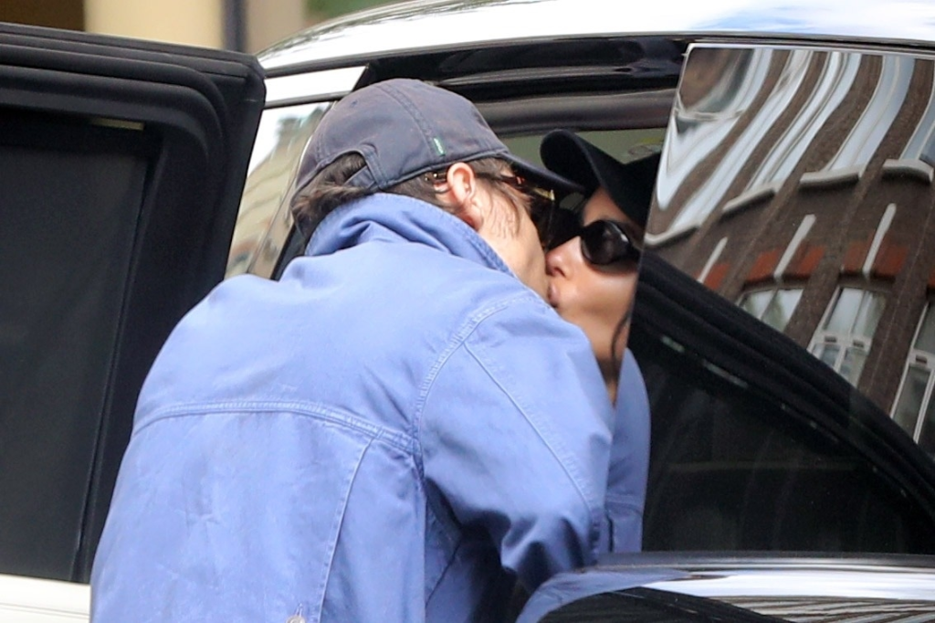 Harry Styles and Zoë Kravitz kissing by a car.