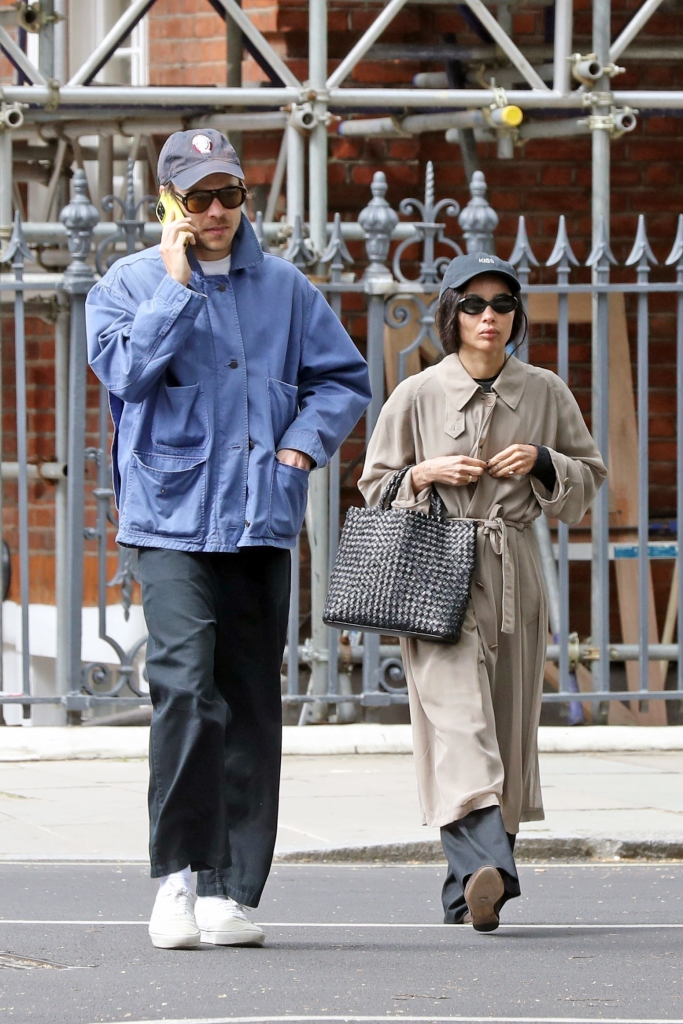 Harry Styles on the phone and Zoe Kravitz wearing a cap that says 