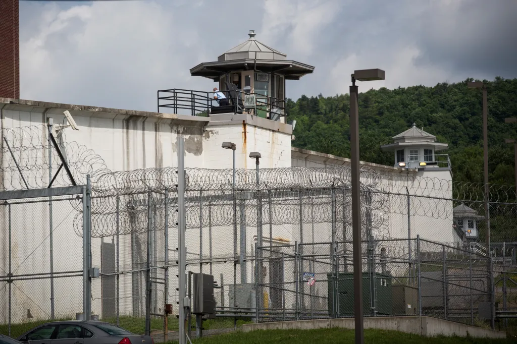A guard in a tower overlooking razor-wire fences outside Clinton Correctional Facility.