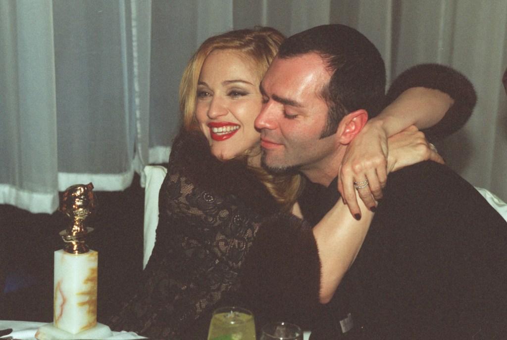 Madonna and Christopher Ciccone embracing next to her Golden Globe award.