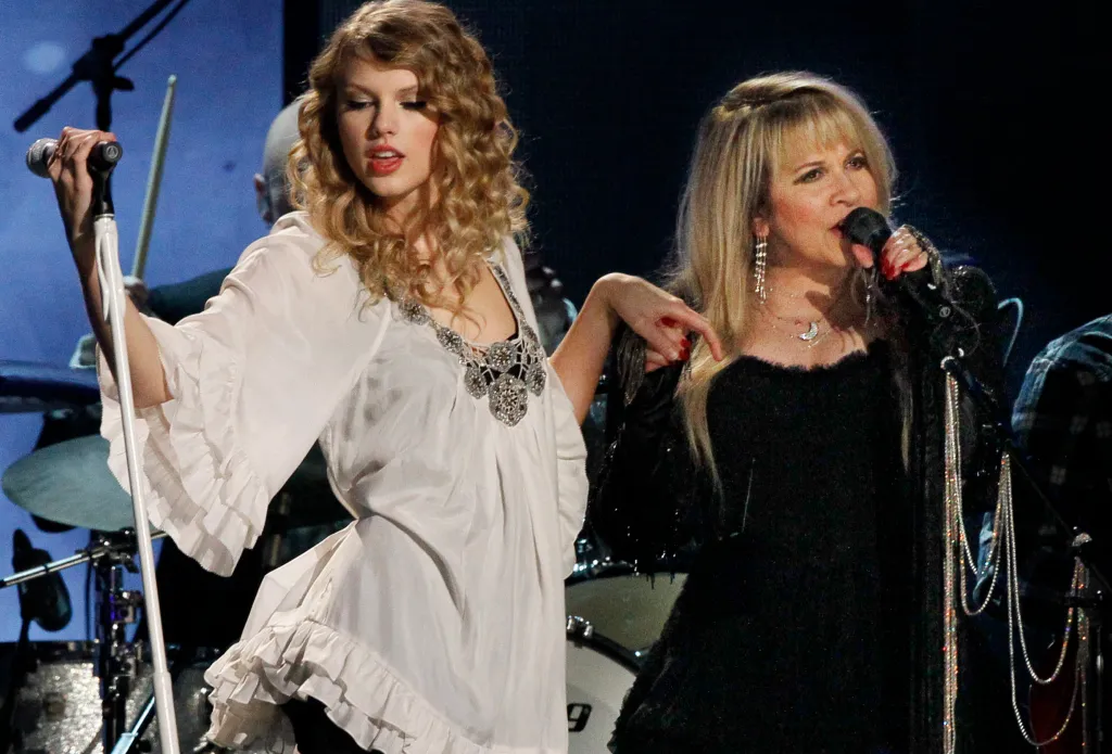 Taylor Swift, in a white tunic, and Stevie Nicks, in a black dress, performing at the 52nd Annual GRAMMY Awards.